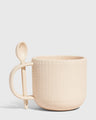 Shortbread 14 oz. Stoneware Spoon Mug (Angle): Cream speckled stoneware mug with knit texture and attached ceramic spoon