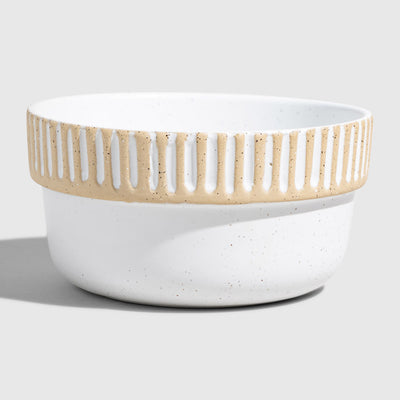 Eggshell Stoneware Stackable Bowl (Angle): Round white speckled ceramic bowl with carved vertical stripe band near rim