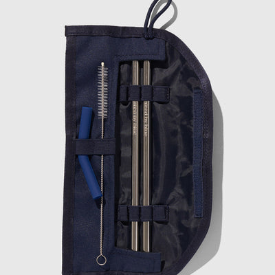 Navy The Straw Kit (Flat-lay): Open navy roll case displaying two metal straws, cleaning brush, and silicone tips